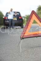 Driver Broken Down On Country Road With Hazard Warning Sign In F