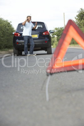 Driver Broken Down On Country Road With Hazard Warning Sign In F