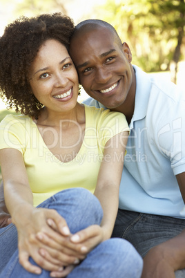 Portrait Of Young Couple Sitting In Park