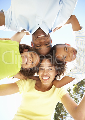 Portrait of Happy Family Looking Down Into Camera In Park
