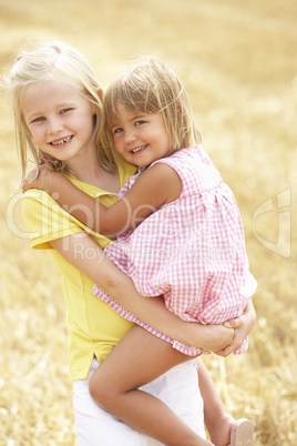 Children Having Fun In Summer Harvested Field