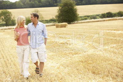 Couple Walking Together Through Summer Harvested Field