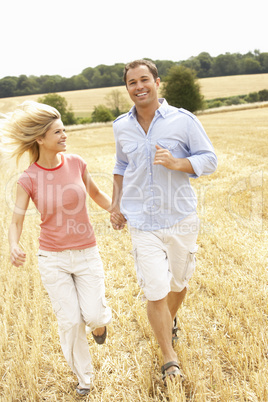 Couple Running Together Through Summer Harvested Field