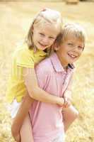 Portrait Of Boy And Girl In Summer Harvested Field