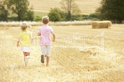 Children Running Through Summer Harvested Field