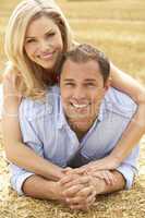 Couple Relaxing In Summer Harvested Field