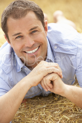 Portrait Of Man Laying In Summer Harvested Field