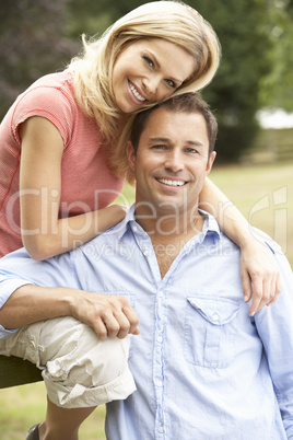 Couple Relaxing In Countryside Sitting On Fence