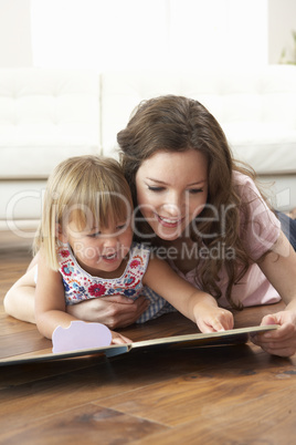 Mother And Daughter Learning To Read At Home
