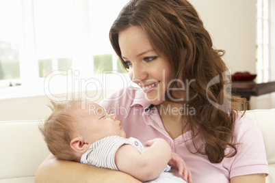 Close Up Of Affectionate Mother Cuddling Baby Boy At Home