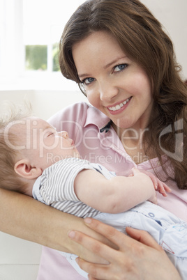 Close Up Of Affectionate Mother Cuddling Baby Boy At Home