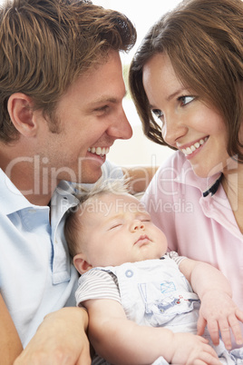 Close Up Of Parents Cuddling Newborn Baby Boy At Home