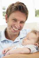 Close Up Of Father Cuddling Newborn Baby Boy At Home