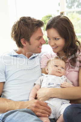 Parents Cuddling Newborn Baby Boy At Home
