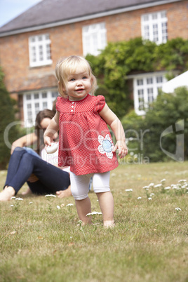 Family Playing Together In Garden At Home