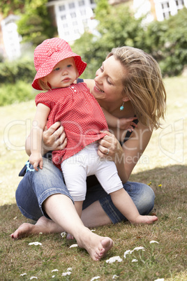 Mother And Daughter Playing Together In Garden At Home