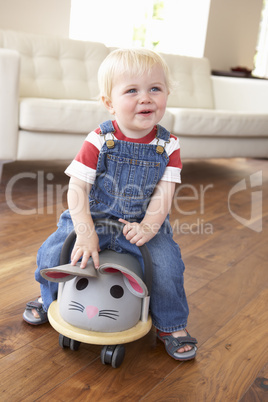 Young Boy Playing With Ride On Toy Mouse At Home
