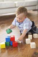 Young Boy Playing With Coloured Blocks At Home