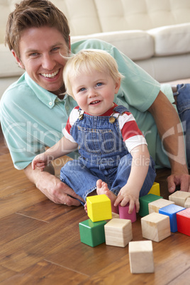 Father And Son Playing With Coloured Blocks At Home