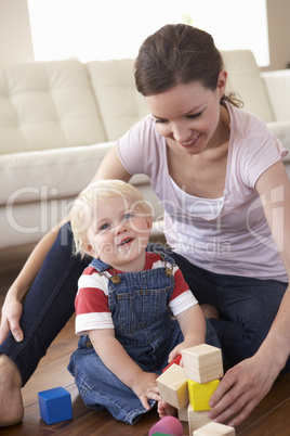 Mother And Son Playing With Coloured Blocks At Home