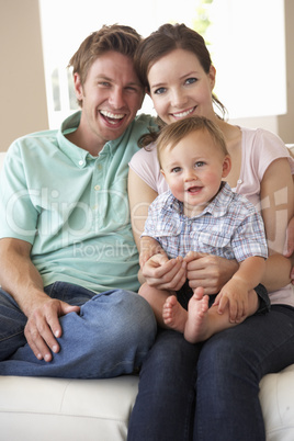 Family Sitting On Sofa At Home Together