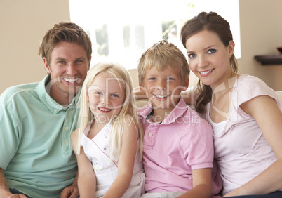 Family Sitting On Sofa At Home Together