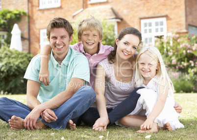 Family Sitting In Garden Together