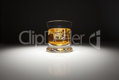 Glass of Whiskey and Ice Under Spot Light.