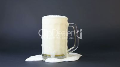 Beer foam is poured from a cup