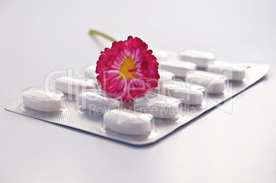 White round pill with daisy