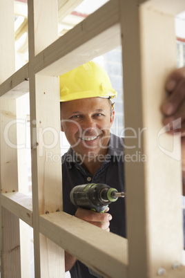 Construction Worker Building Timber Frame In New Home