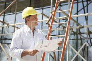 Architect Studying Plans Outside New Home