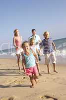 Portrait Of Running Family On Beach Holiday