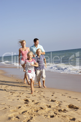 Portrait Of Running Family On Beach Holiday