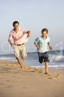 Father And Son Running Along Summer Beach