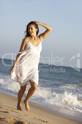 Young Woman Running Along Summer Beach