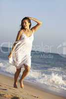 Young Woman Running Along Summer Beach