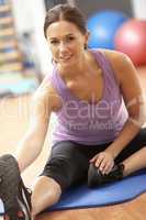 Woman Doing Stretching Exercises In Gym