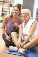 Woman Doing Stretching Exercises In Gym With Trainer
