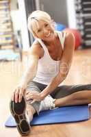Senior Woman Doing Stretching Exercises In Gym