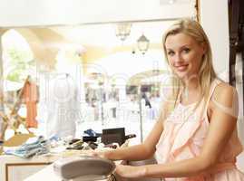 Female Sales Assistant At Checkout Of Clothing Store