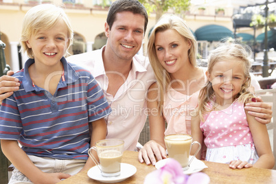 Young Family Enjoying Cup Of Coffee In Caf? Together