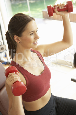 Young Woman Working With Weights In Gym