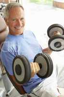 Senior Man Working With Weights In Gym