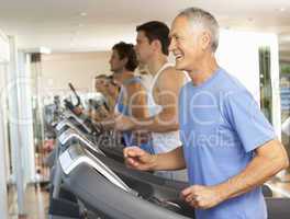 Senior Man On Running Machine In Gym
