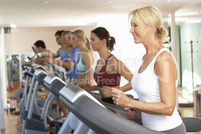 Senior Woman On Running Machine In Gym