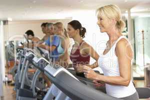 Senior Woman On Running Machine In Gym