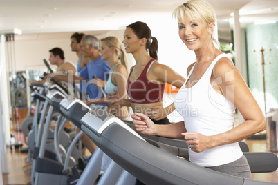Senior Woman On Running Machine In Gym