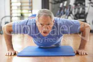 Senior Man Doing Press Ups In Gym