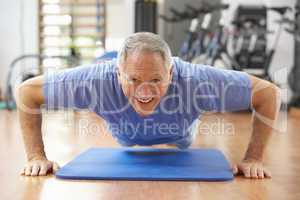Senior Man Doing Press Ups In Gym
